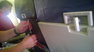 Southwest maintenance technician repairing the tray table latch.
